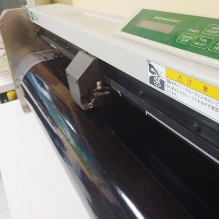 Plotter de corte en proceso de corte de vinilo autoadhesivo negro.